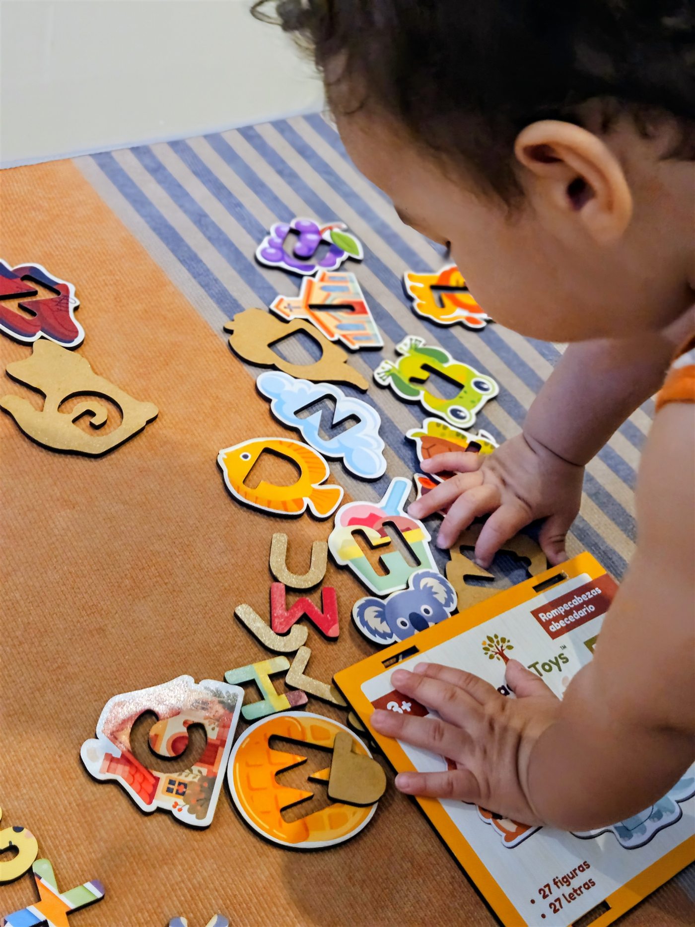 Niño jugando con el rompecabezas Abecedario de Acacia Toys